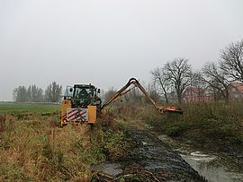 Traktor bei der maschinellen Sohlkrautung und Böschungsmahd in Pastow